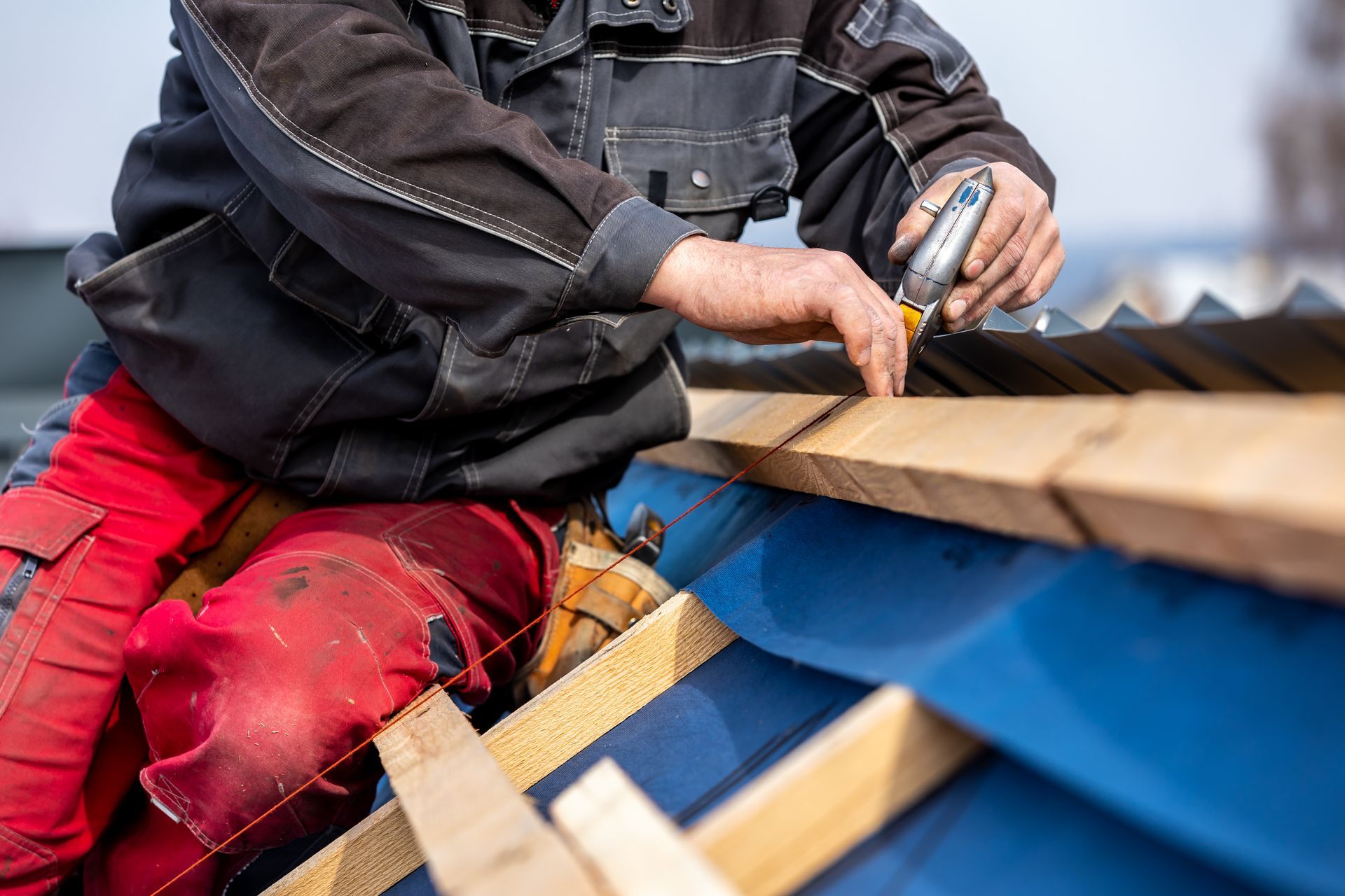 Un homme travaille sur un toit avec un tournevis.