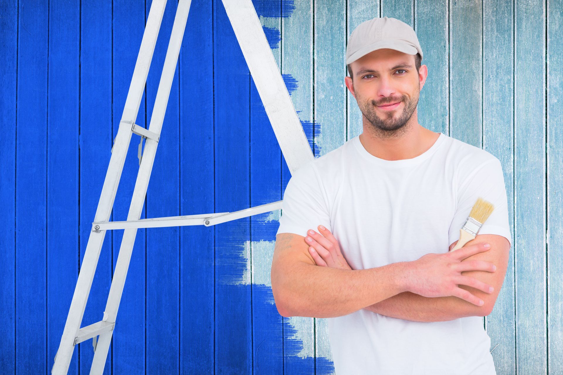 Un homme tient un pinceau devant un mur bleu.