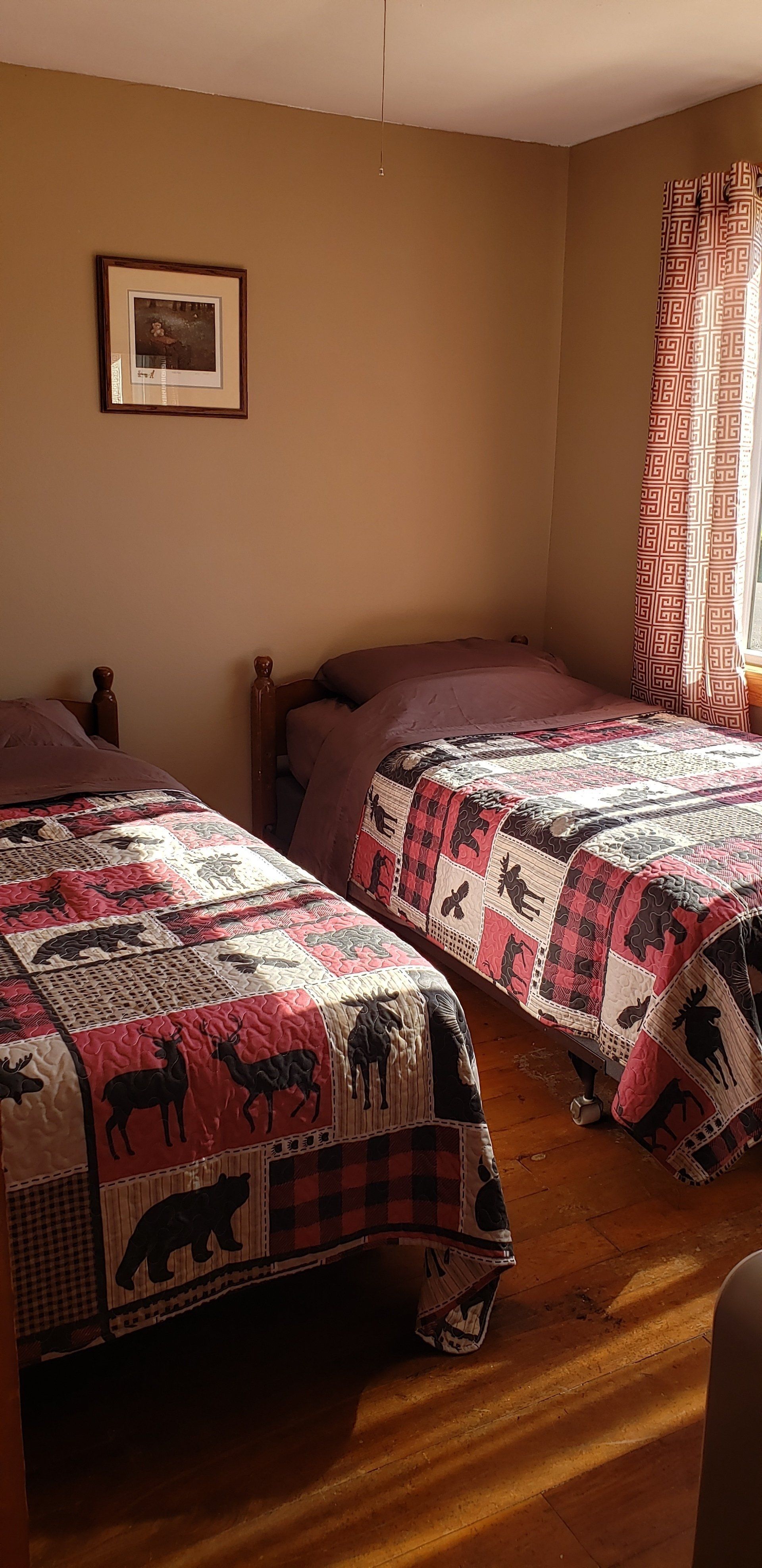 A bedroom with two twin beds and a window.