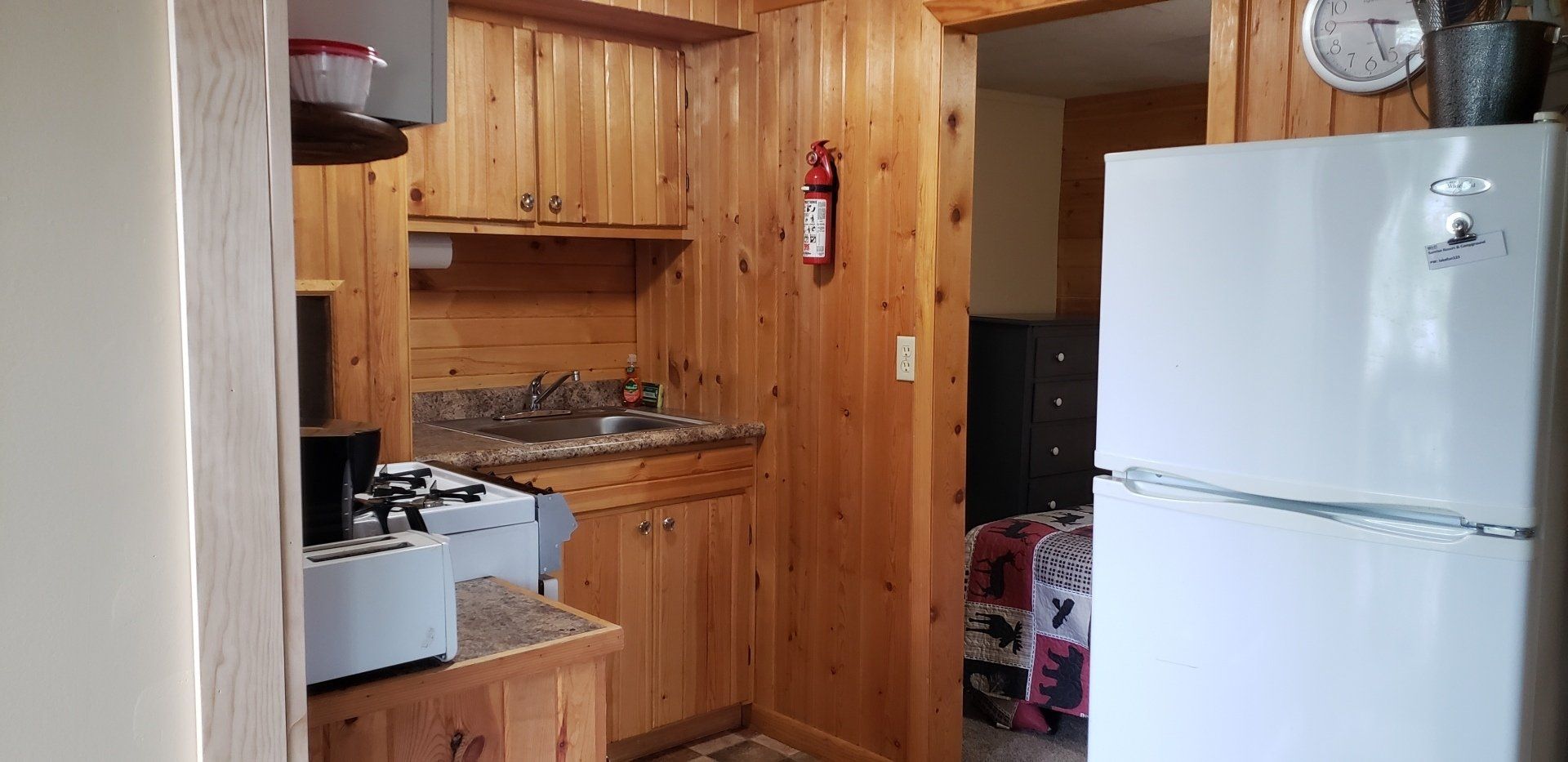 A kitchen with wooden cabinets and a white refrigerator.