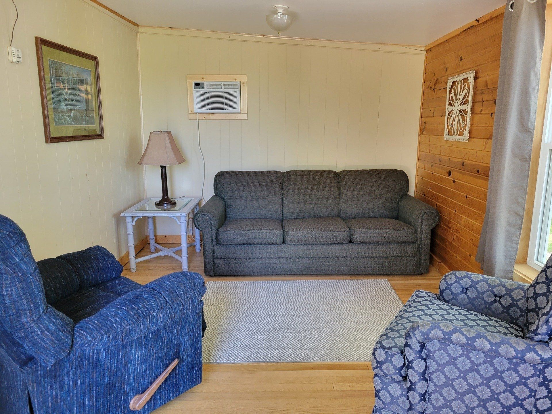 A living room with a couch and two chairs