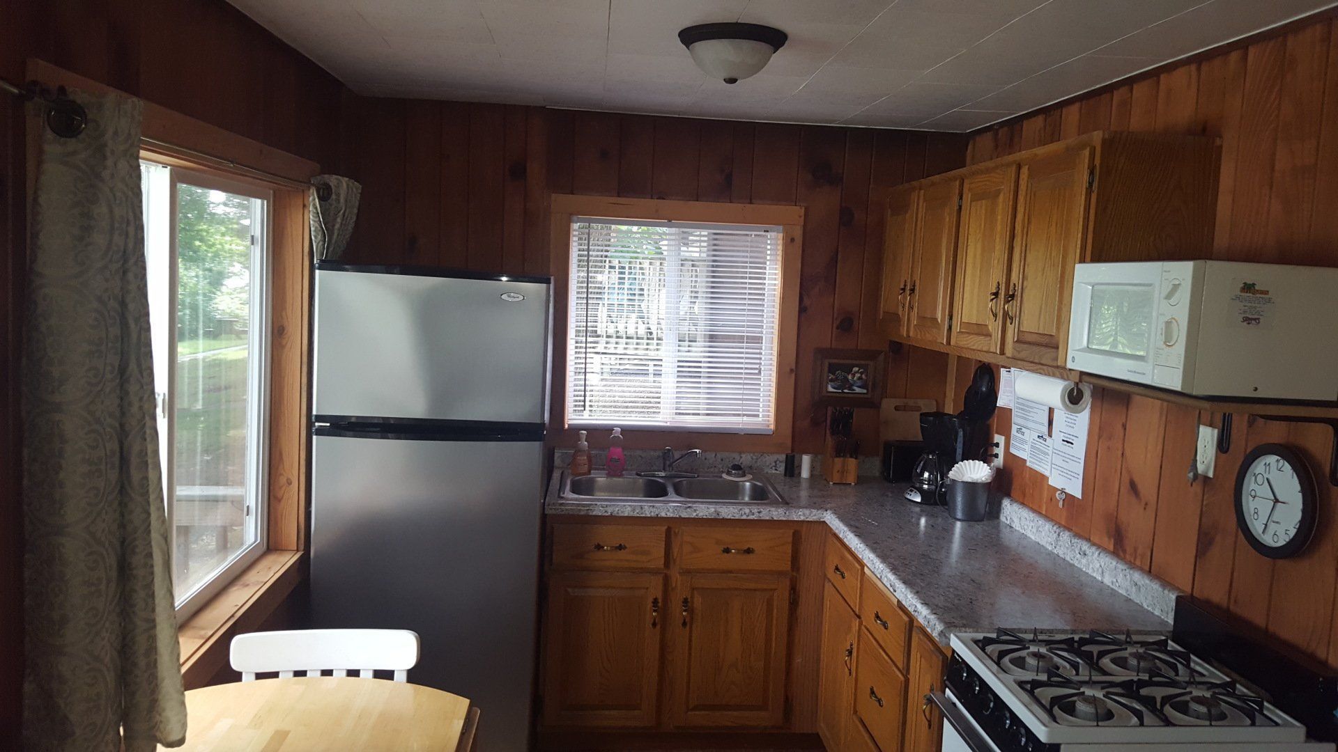 A kitchen with a stove a refrigerator and a microwave