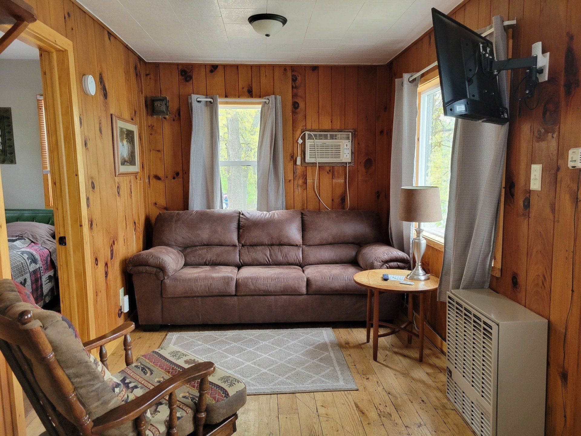 A living room with a couch , chair , table and television.
