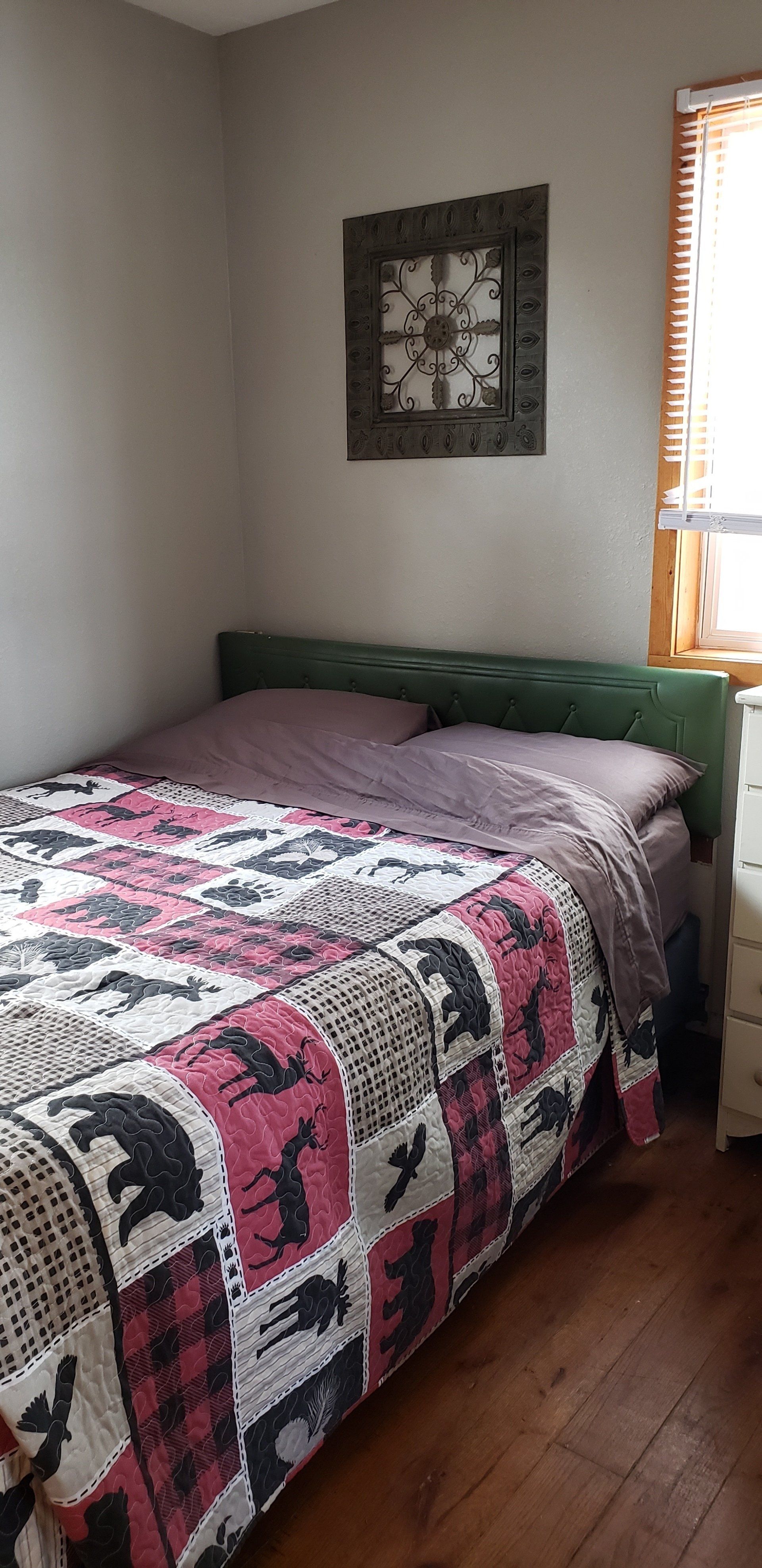 A bedroom with a bed and a clock on the wall.