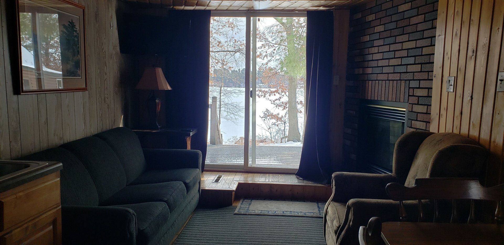 A living room with a couch , chairs , and a large window.