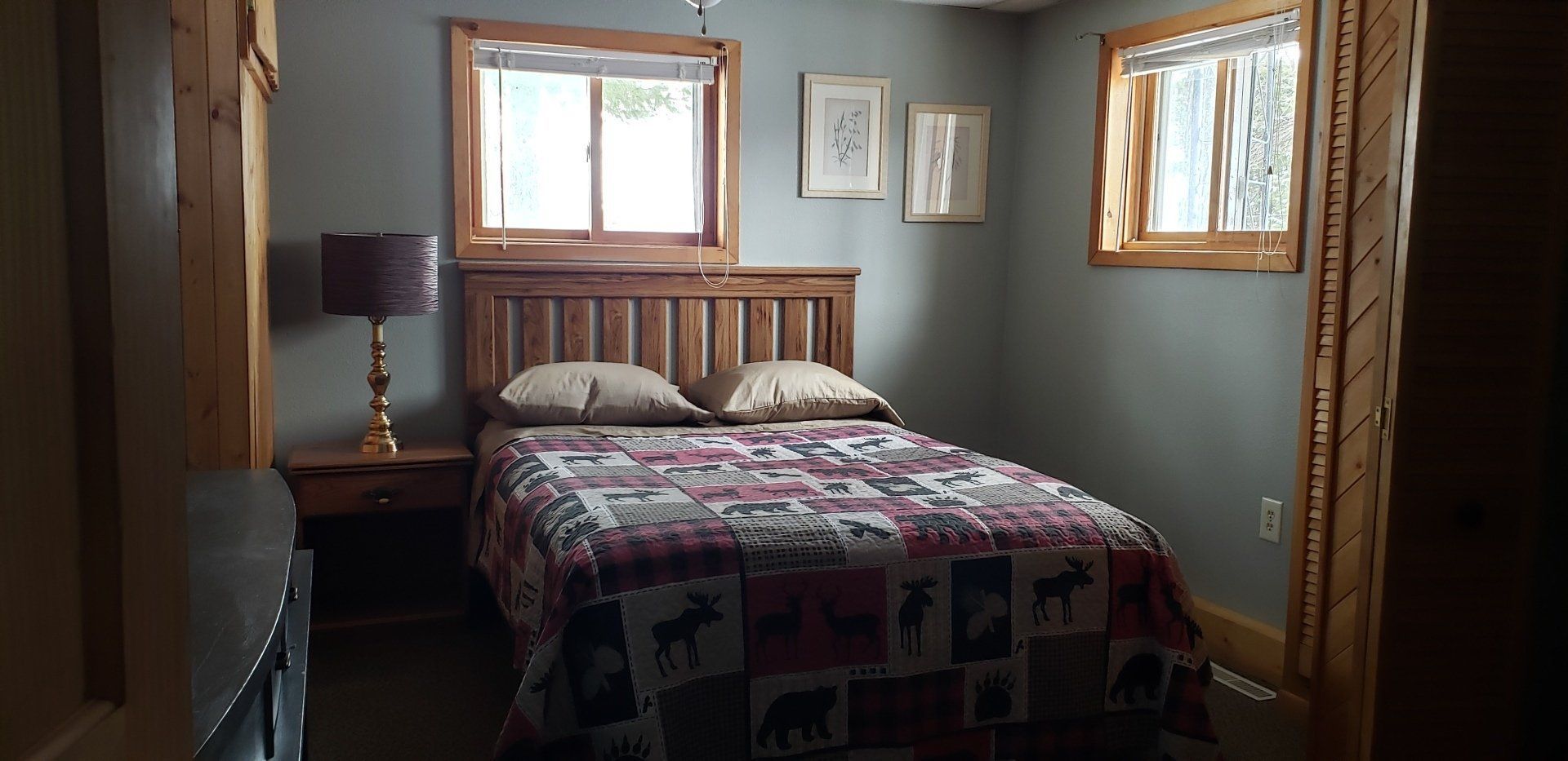 A bedroom with a bed and two windows