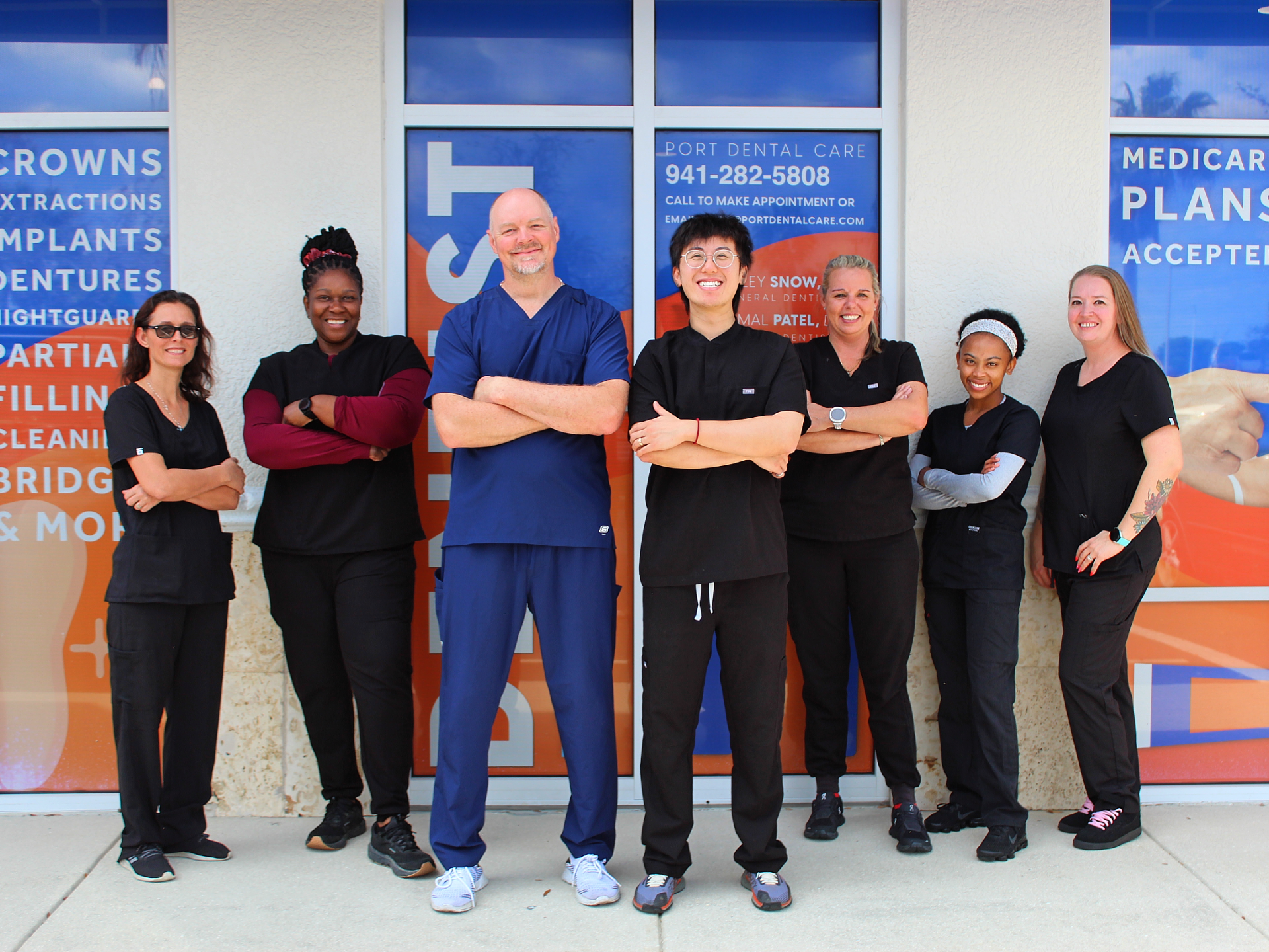 Six healthcare staff stand smiling with arms crossed outside a medical spa clinic.