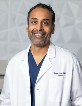 Man in white lab coat smiles. Text reads 