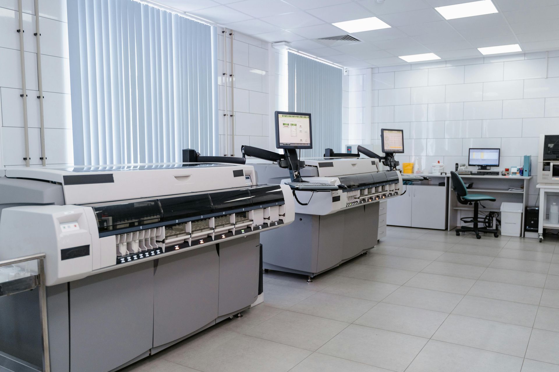 Industrial print shop with large printing machines and computer workstations in a bright office-like room