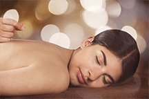 A woman is laying on a table getting a massage.