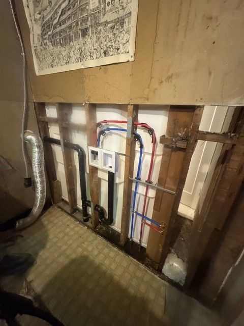 Open wall with exposed plumbing and pipes in a home renovation area