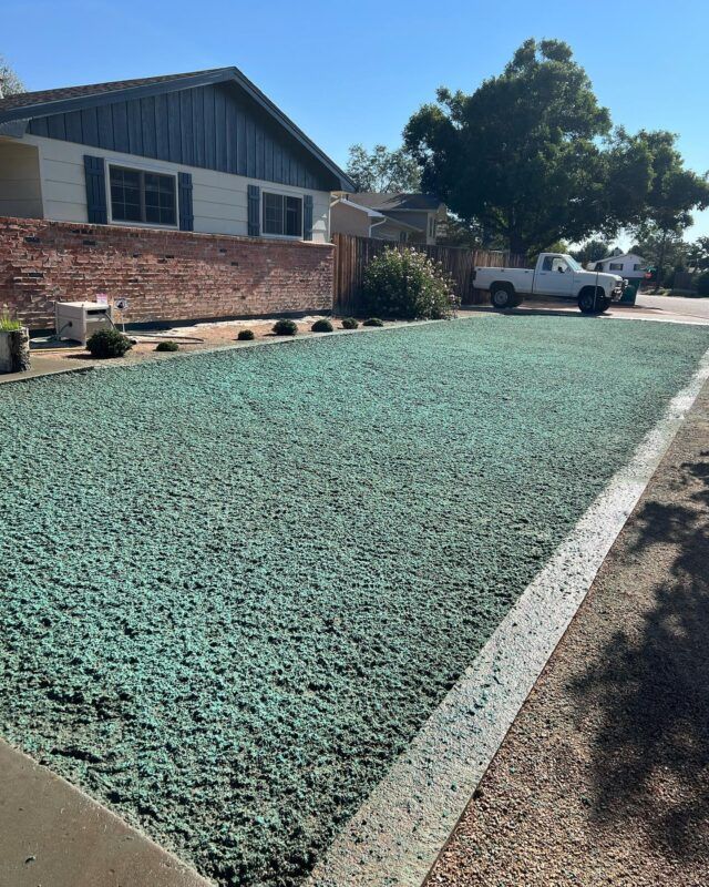 Front yard with green gravel landscaping, brick house, and white truck parked by the curb.