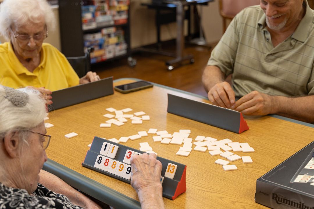 A group of people are playing a game of dominoes at a table.