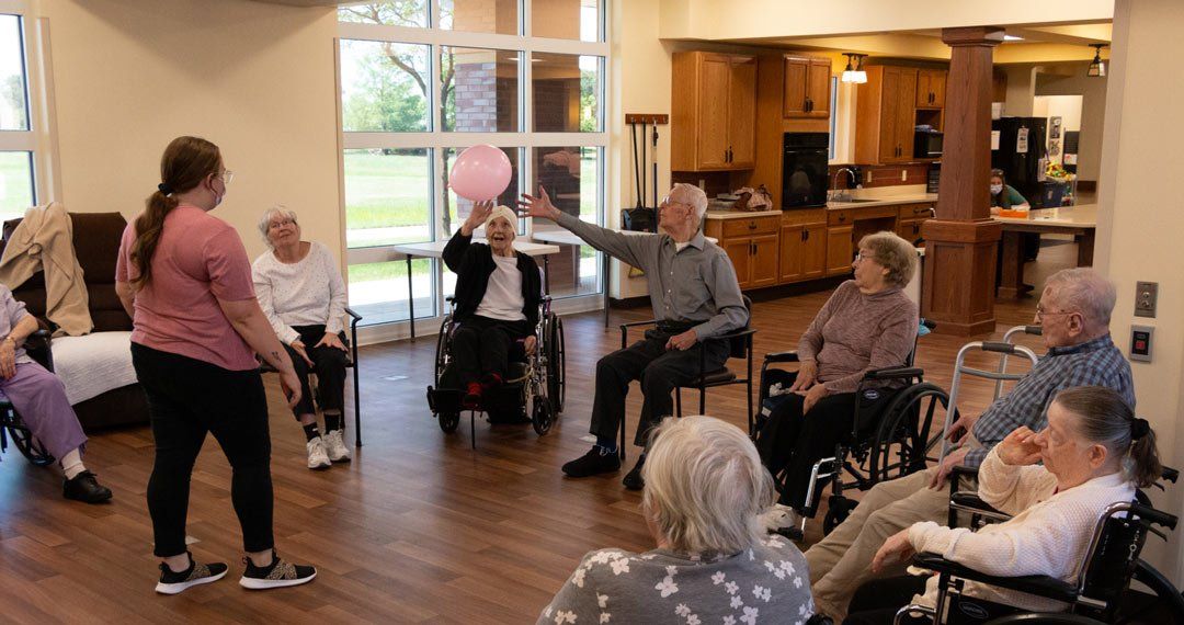 A group of elderly people are sitting in a circle in a room.