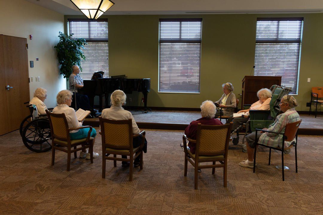 A group of elderly people are sitting in a circle in a room.