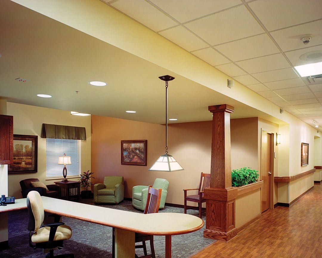 A hallway with a table and chairs and a lamp hanging from the ceiling
