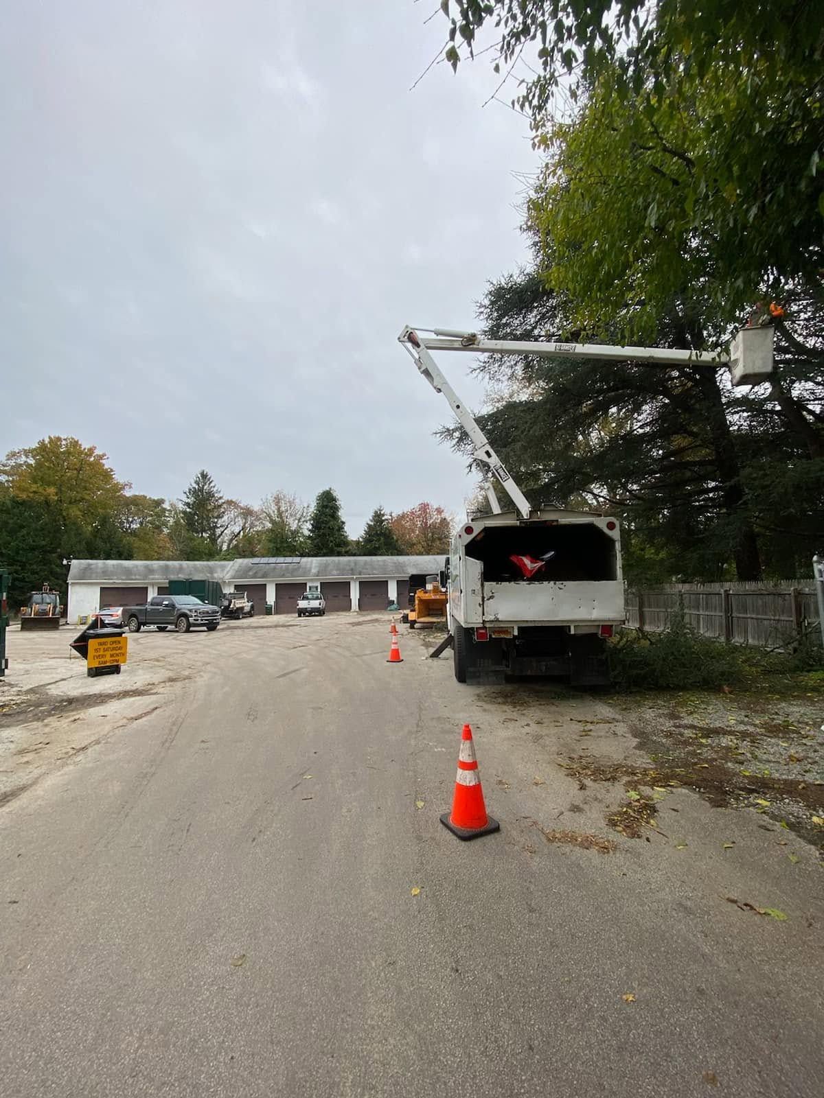 Construction site road with a white utility truck, orange cones, and debris along the roadside