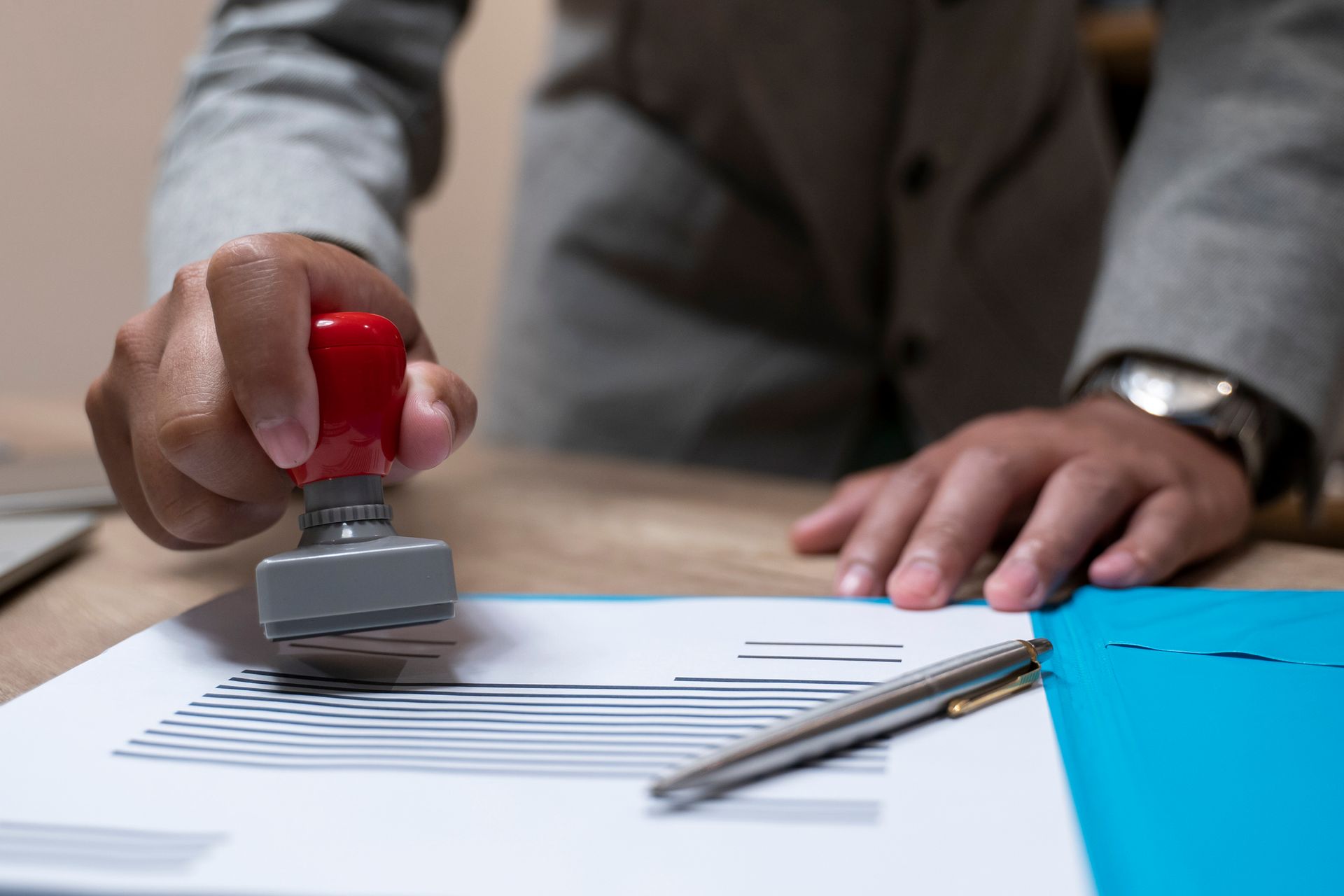 A person is stamping a document on a table.