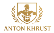 Gold logo featuring a muscular figure inside a crest, flanked by laurel wreaths, above the text 