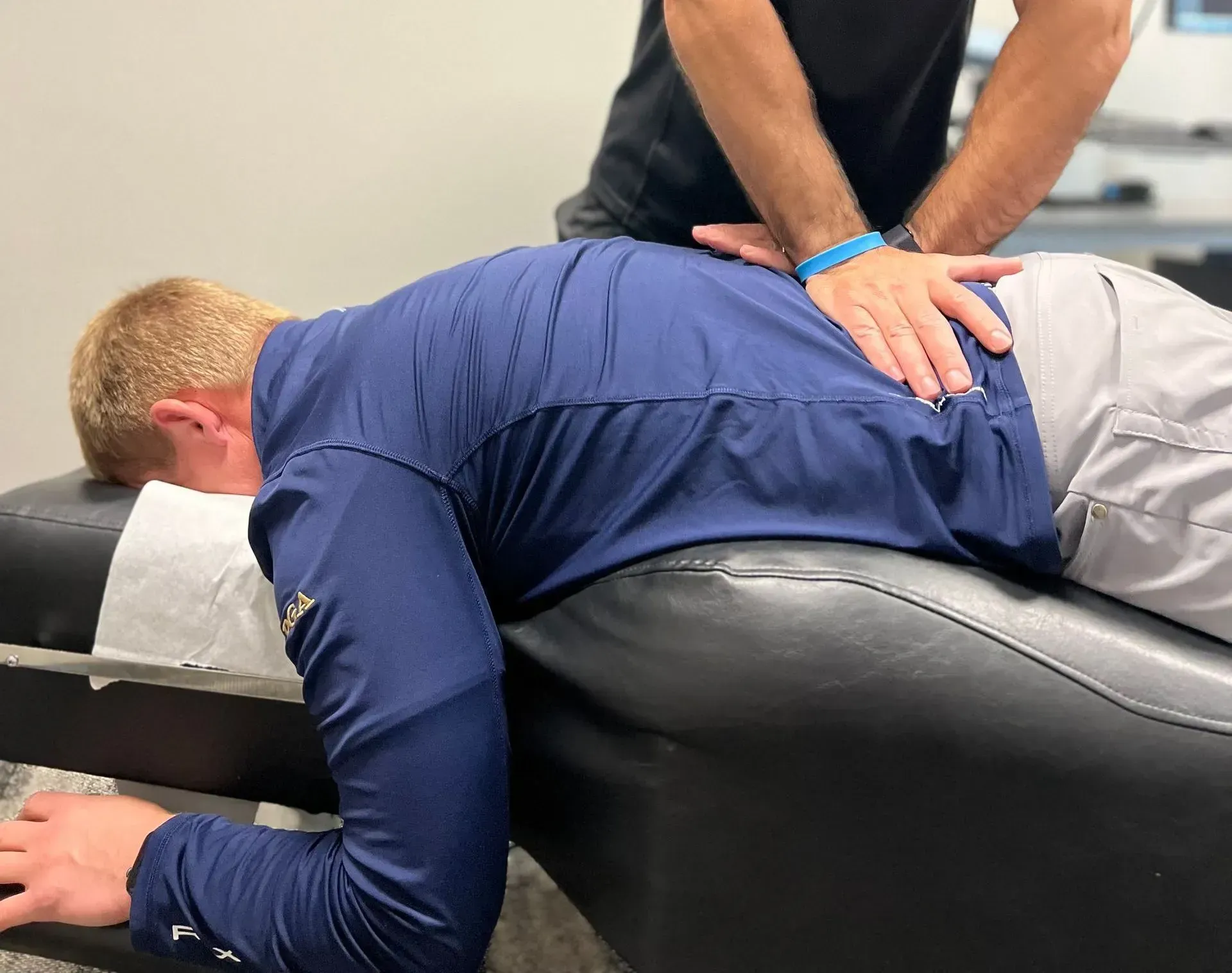 Person receiving chiropractic treatment; back adjustment.