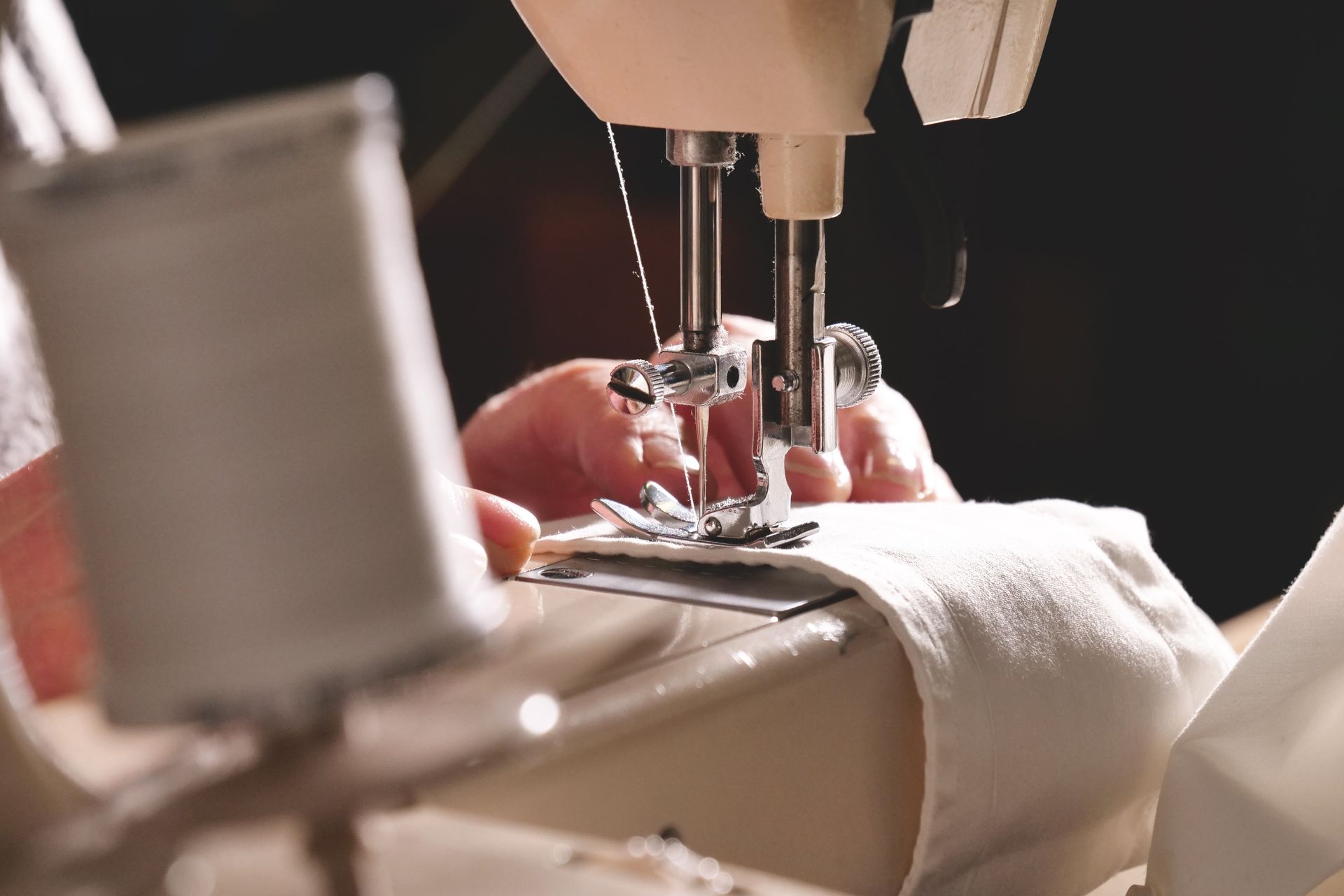 Person using a sewing machine to stitch fabric