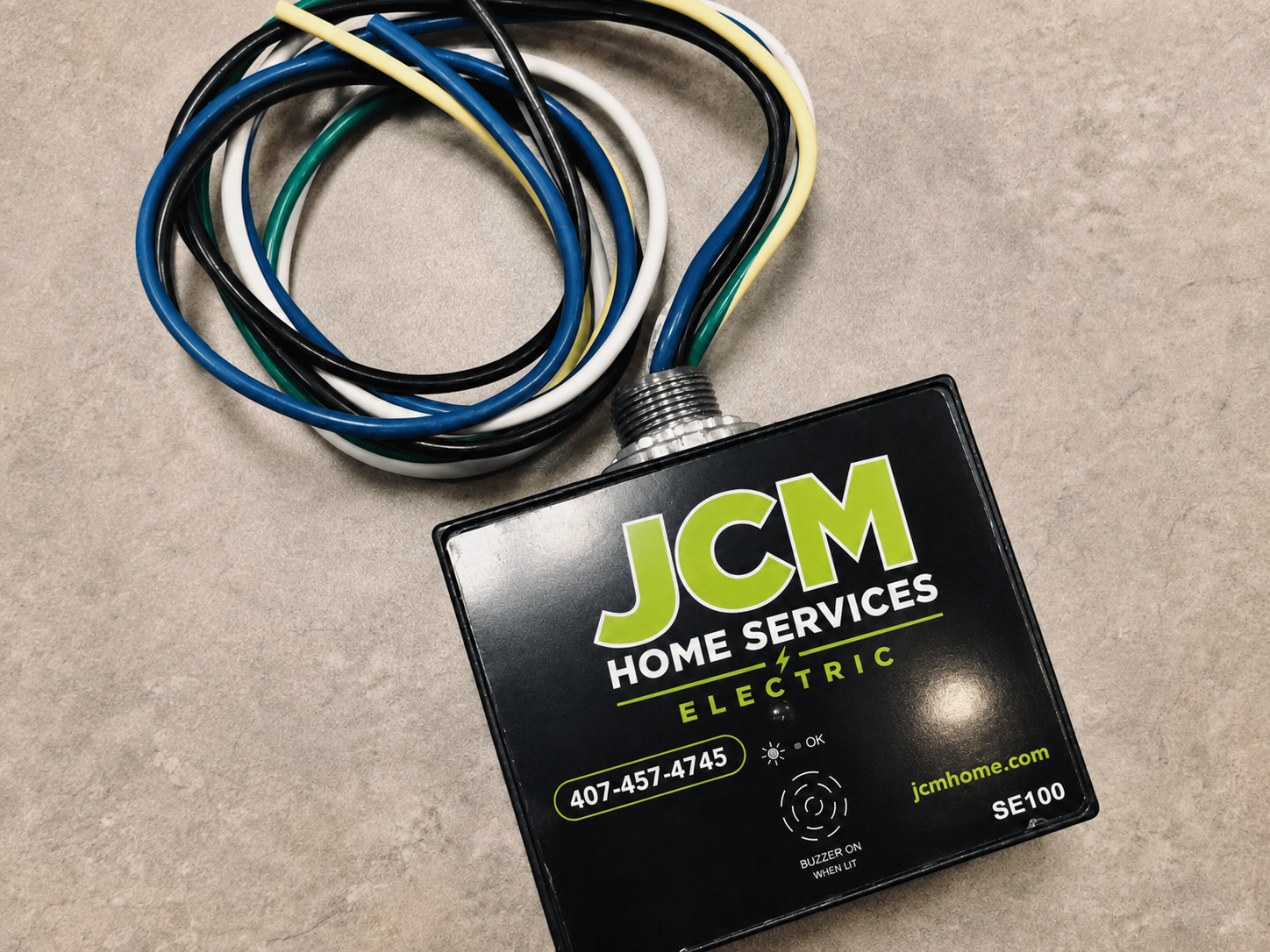 JCM Home Services electrical thermostat with coiled wires on a countertop