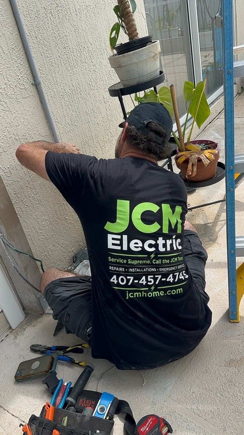 JCM electrician working at an exterior wall.