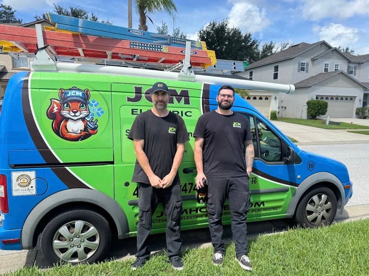 JCM Electric team standing beside the branded service van with ladders