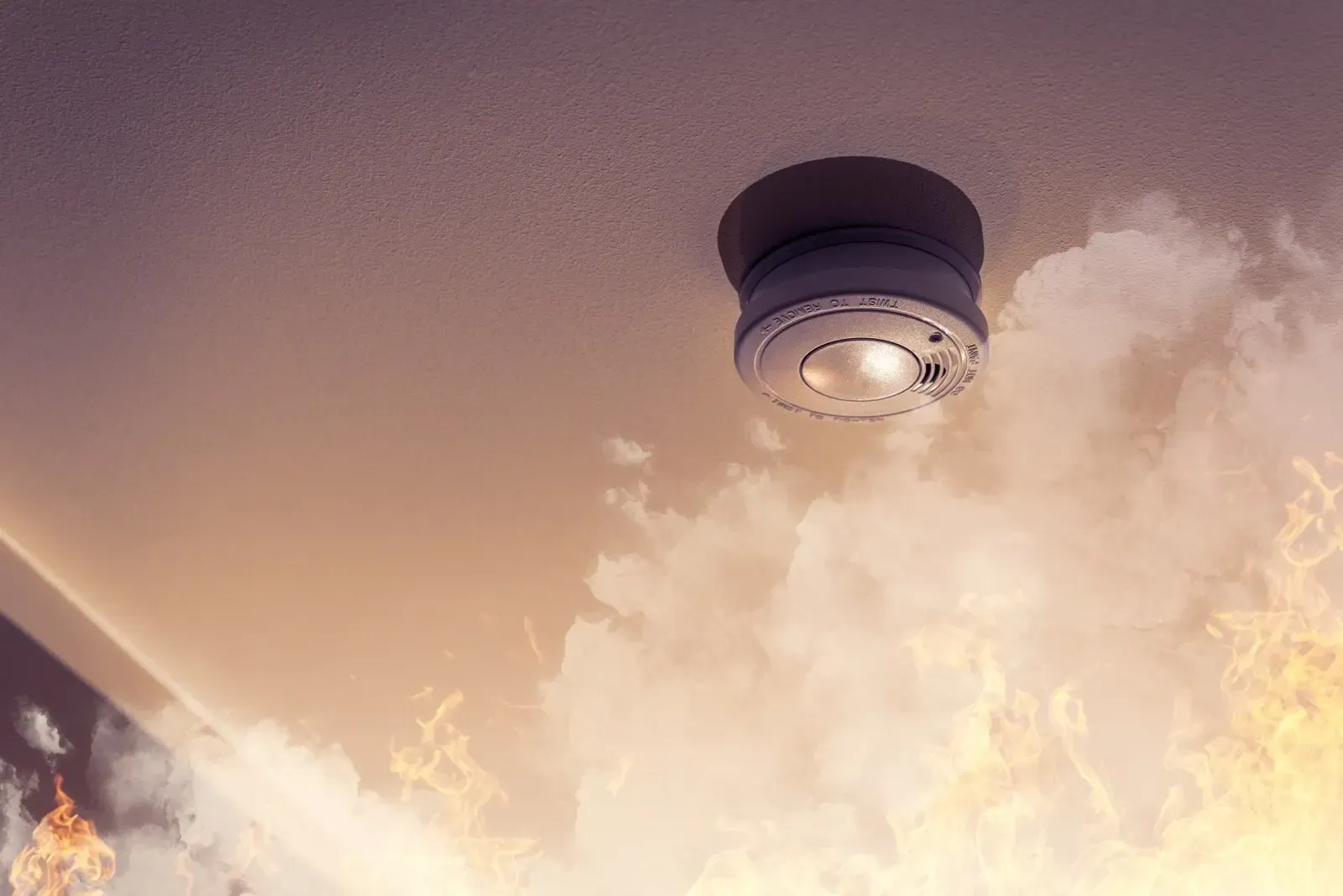 Ceiling-mounted smoke detector on a pale ceiling with smoke or steam billowing below