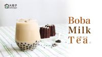 Boba milk tea in a glass with tapioca pearls on a light striped table, with two chocolate treats beside it.