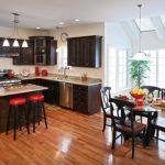A kitchen and dining room with hardwood floors and stainless steel appliances.
