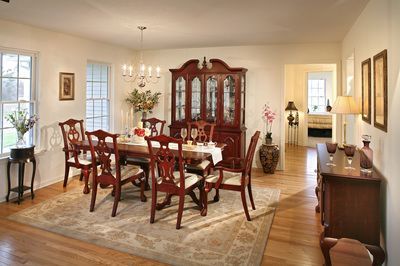 A dining room with a table and chairs and a hutch