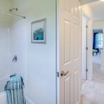 A bathroom with a tub , shower , and mirror.