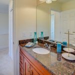 A bathroom with two sinks and a large mirror.