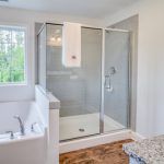 A bathroom with a walk in shower and a bathtub.