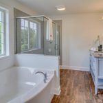 A bathroom with a tub , sink , and shower.