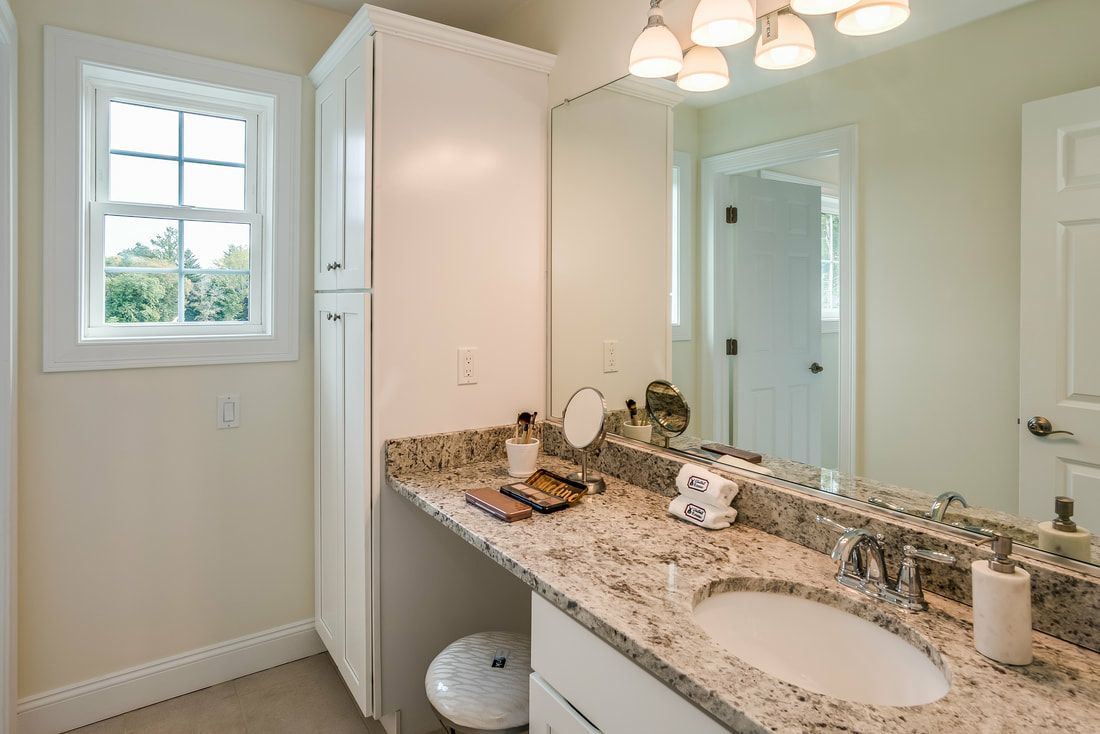 A bathroom with two sinks , a mirror and a window.
