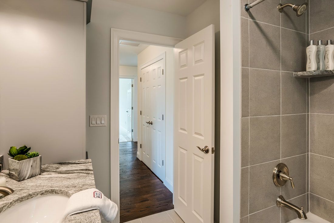 A bathroom with a sink , shower , and walk in closet.