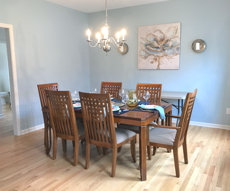 A dining room with a table and chairs and a chandelier