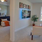 A living room with a dining table , chairs , and a ceiling fan.