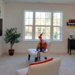 A living room with a couch , chair , table and window.