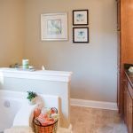 A bathroom with a tub and a basket of soap on the floor.