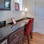 A kitchen with a desk and chair in it.