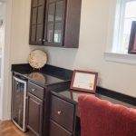 A kitchen with a refrigerator , cabinets , a desk and a chair.