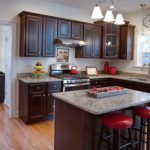 A kitchen with wooden cabinets , granite counter tops , stainless steel appliances , and a large island.