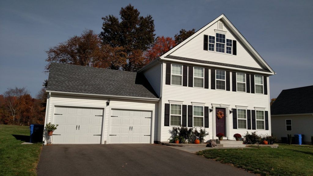 A white house with a gray roof and black shutters