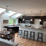 A kitchen with a table and stools and a large island.