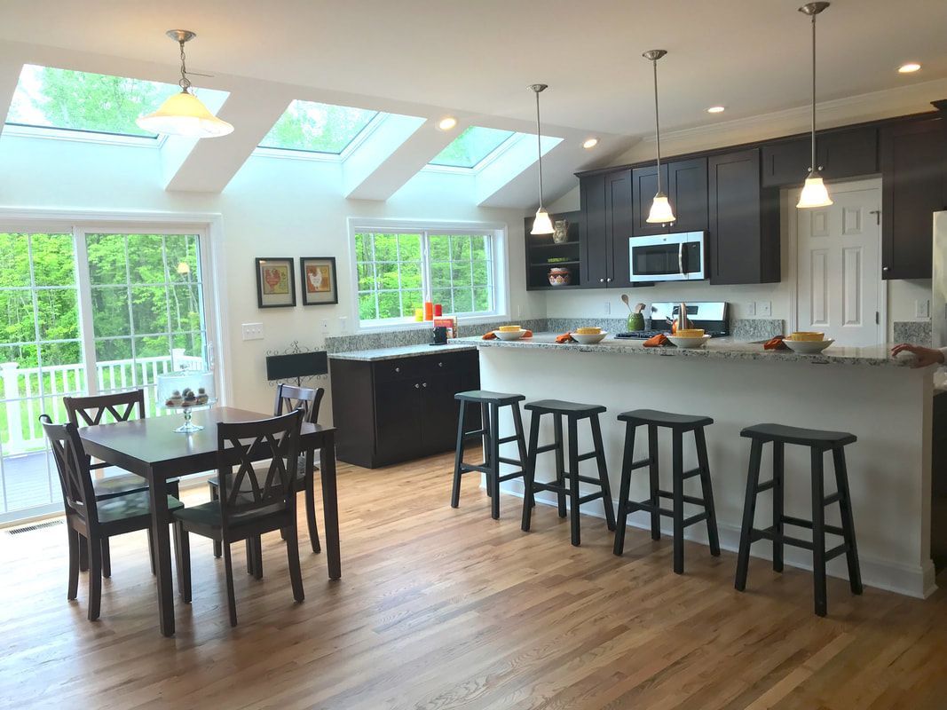 A kitchen and dining room in a house with a table and chairs.