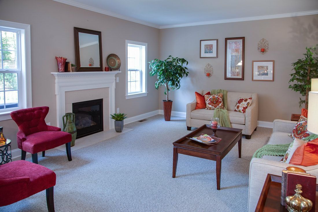 A living room with a couch , chairs , coffee table and fireplace.