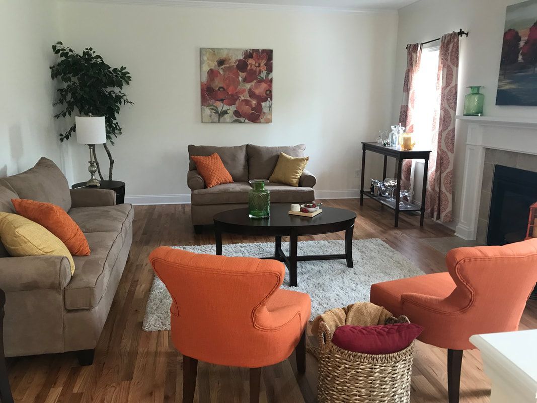 A living room with a couch , chairs , coffee table and fireplace.